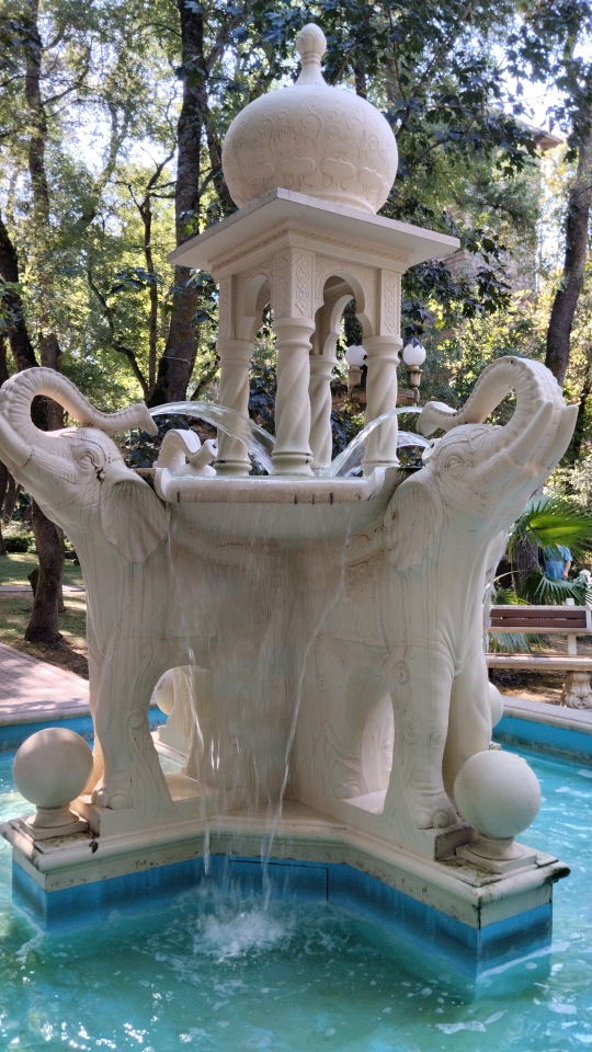 A water fountain featuring sculpted white elephants.