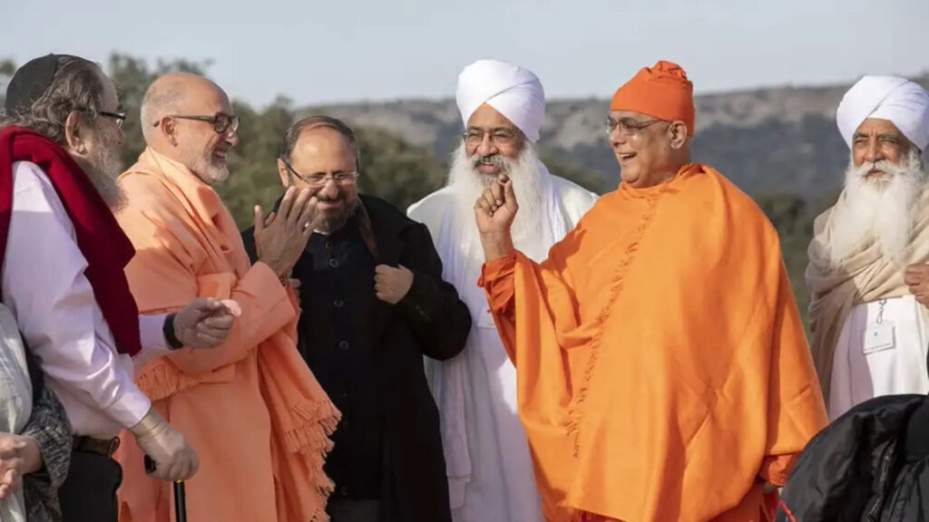 A group of men of diverse religions standing together in friendship. They are outside in nature.