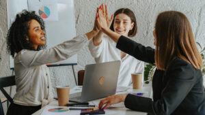 Three women high-fiving for the Youth for Peace: UNESCO Intercultural Leadership Programme